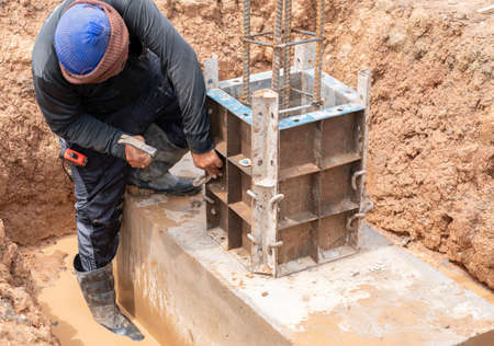 Worker assembly formwork foundation pole for pour concrete in construction site.の写真素材