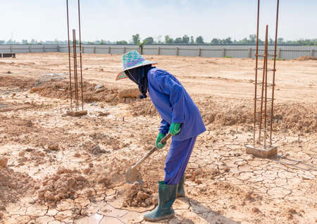 Workers are using a shovel to adjust the soil in construction siteの写真素材
