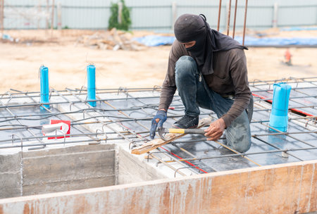 Worker removing the nail from the wooden chip in building construction site.の写真素材