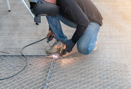Worker used electric welding wire mesh door in factory.の写真素材
