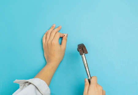 The carpenter hit nail on Aqua blue wall, isolate Aqua green background.の写真素材