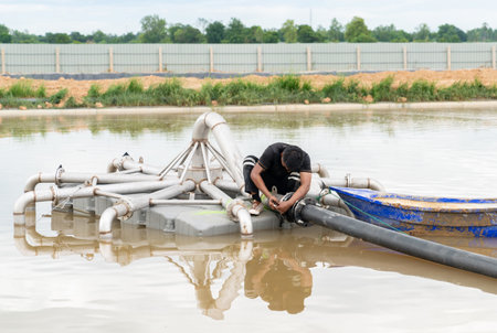 Worker tighten nut flange pipe on aerator float in water treatment pond.