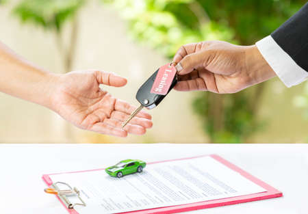 Car leasing give keys to customer and model, document on out of focus background. financial and leasing concept.の写真素材