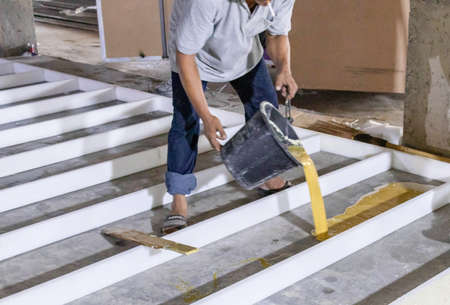 Worker pour mixed pu foam chemical on block floor for protective moisture from ground.