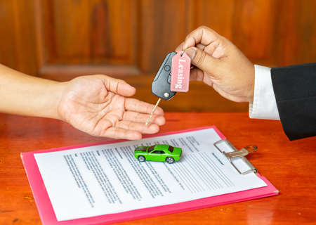 Closeup hand giving a car key finish for loan credit financial, lease and rental conceptの写真素材