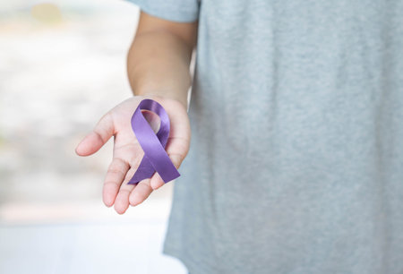 Purple ribbon in hold hand concept of world cancer day.の写真素材