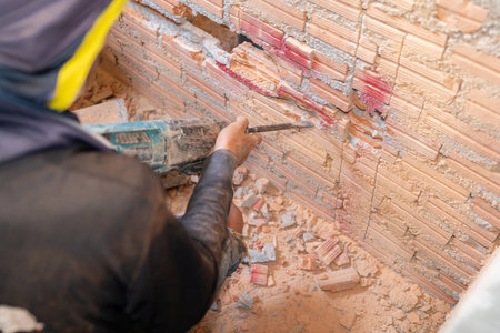 Electric hammer drill hole in wall at building site.の写真素材