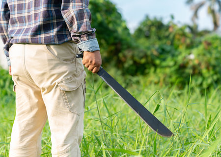 The man hold trekking blade for mow camping. Camping travel.