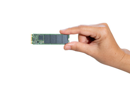 A hand holds an ssd disk of m2 format isolate on white background. New technologies for storage and fast data transferの写真素材