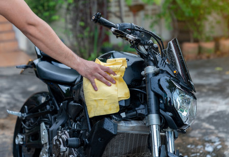 Biker man cleaning motorcycle , Polished on fuel tank in laundry area.の写真素材