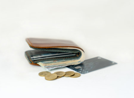 Coin, Dollar bills and credit card on brown wallet isolate on white background.の写真素材
