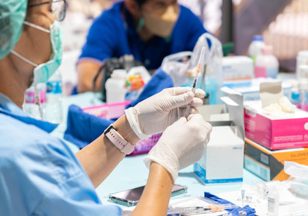 Nurse drawing up solution and filling syringe in station.の写真素材