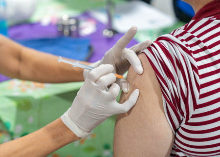 Close up of woman getting injected with a vaccine in sholder arm. Health care.の写真素材