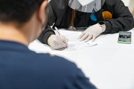 Medical worker fill inject vaccine form for screen health history before got vaccine.