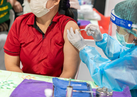 Close up of woman getting injected with a vaccine in upper arm.の写真素材