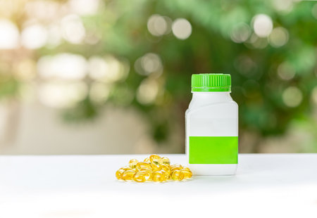 Cod liver oil gel capsules the omega 3 vitamin laying on the floor next to the pill bottle.の写真素材