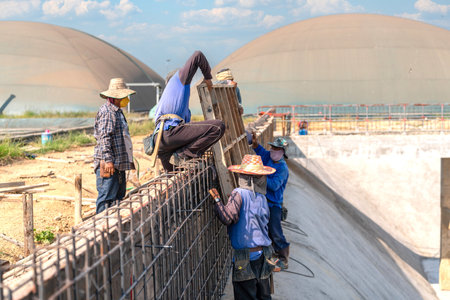 Workers are lifting formwork for concrete pouring for treatment pond.の写真素材