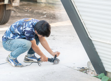 Worker use stone grinding machine cut road floor for tube embeded.の写真素材