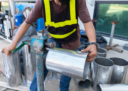 Worker turn rolled steel sheet rim on plate rolling machine in factoryの写真素材