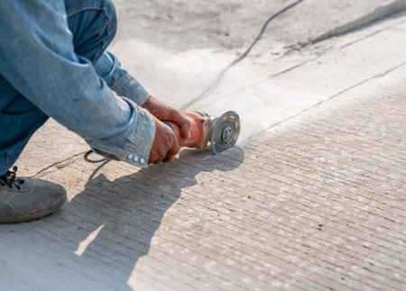 Grinder worker cuts concrete floor the electric tool,street construction workの写真素材