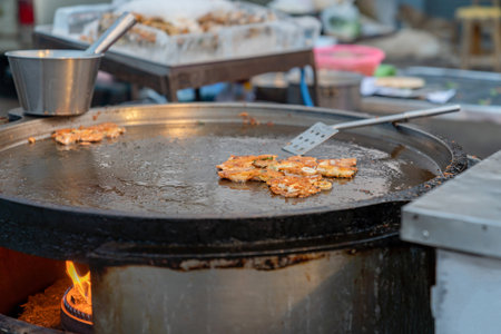 Chef cooking fried clams in big pan in night barzar, Thai foodの写真素材