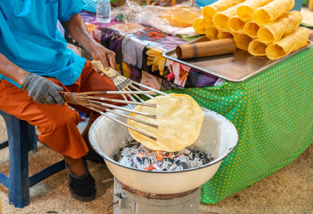 The old woman grilled crackers on charcoal, old thai crackers in street food market.の写真素材