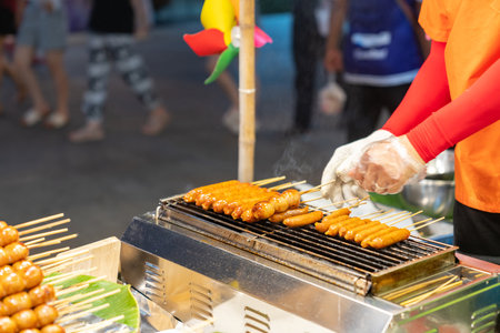 Chef grilled meat ball and sausage on smokeless grill in street food marketの写真素材