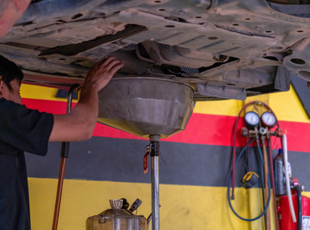 Technician use oil tub under engine for change lubricant car. Energy fuel concept.の写真素材