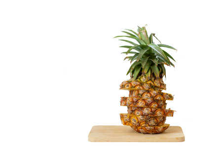Sliced a whole of Pineapple on cutting wooden board isolate white background.の写真素材