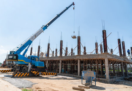 Mobile crain lift up equipment bucket to the second floor on construction site.の写真素材