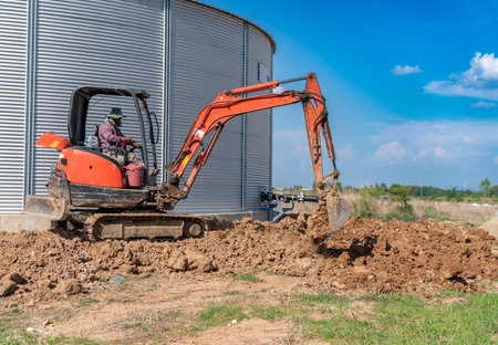 Mini excavator digs a trench at a construction site. Laying of underground around foundation.