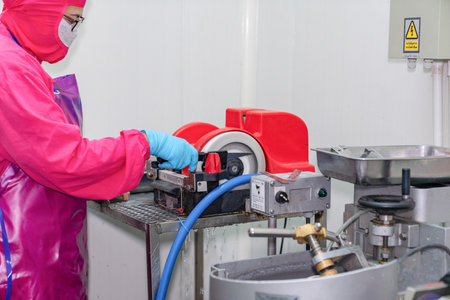 Worker sharpening knife with electric grinding stone in slaughter house.の写真素材