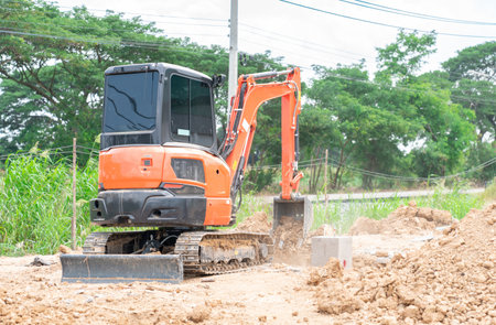 Workman using a mini digger to cover up a hole of foundation pile in the construction site.の写真素材