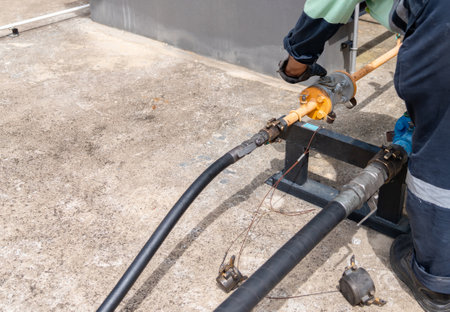 Operator connect pipe and open valve to load LPG liquid tank. LPG gas plant.
