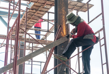 Worker grinding a metal bar support structure remove out after finish install.の写真素材