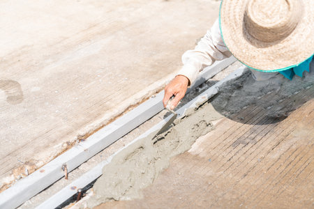 Worker pour cement on iron drainage water sidewalk in factory.の写真素材