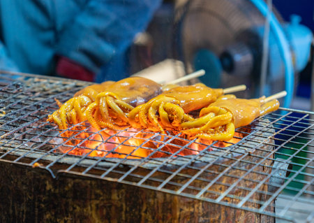 Grilled squid on a charcoal stove at street food.の写真素材