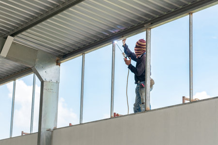 Worker weld metal with a arc welding machine at the construction site.の写真素材