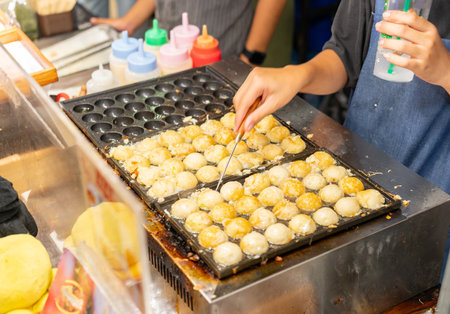 Chef flip takoyaki on hot pan Famous in street foodの写真素材