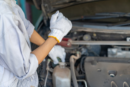 Auto mechanics diagnose engine problem using light tools to finde abnormal parts, ensuring safe vehicle performance.の写真素材