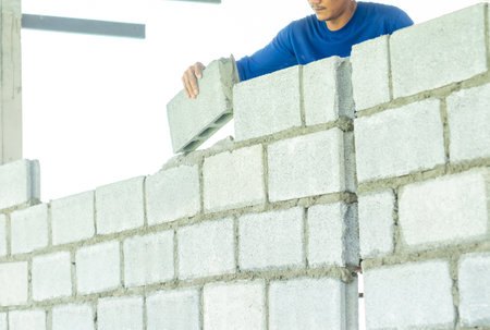 Mansonry install concrete brick for wall of dormitory Brick layer concept.の写真素材