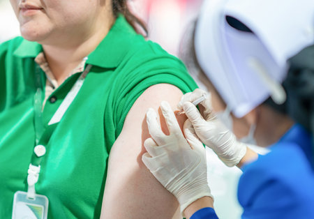 Woman getting a flu or coronavirus vaccine in the clinic.の写真素材
