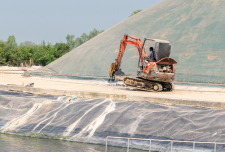 Excavator jack drill concrete floor on water treatment pond in factory.の写真素材