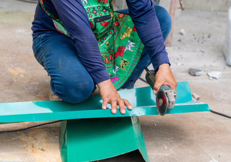The worker is using a metal sheet cutting machine for roofing sheets.