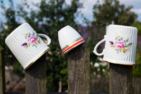 Old cups on the slats of an old fence. Traditional folk ornament. South Moravia, Czech Republic.