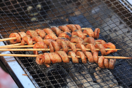 Skewered sausages being grilledの写真素材