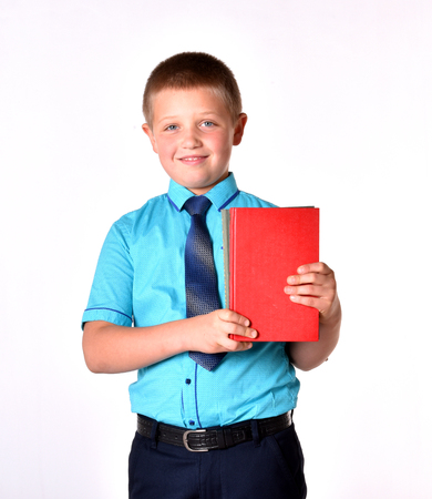 An isolated boy. A boy with books. A schoolboy in a blue shirt. An interest in knowledge.の写真素材