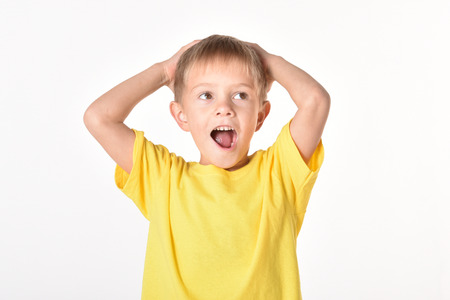 A boy on a white background. A good baby. A beautiful mood. Hands on the head. A great annoyance.の写真素材