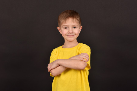 Emotional guy. Portrait of a boy in a T-shirt. Shooting in the studio. A young man on a black background.の写真素材