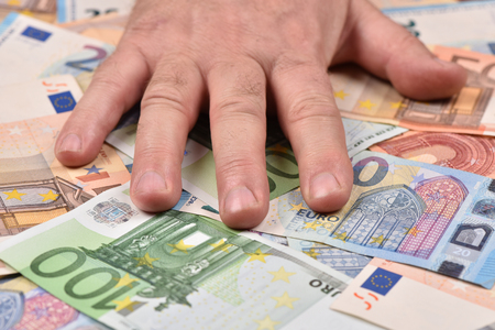 Hand on euro banknotes. Money on the table.の写真素材